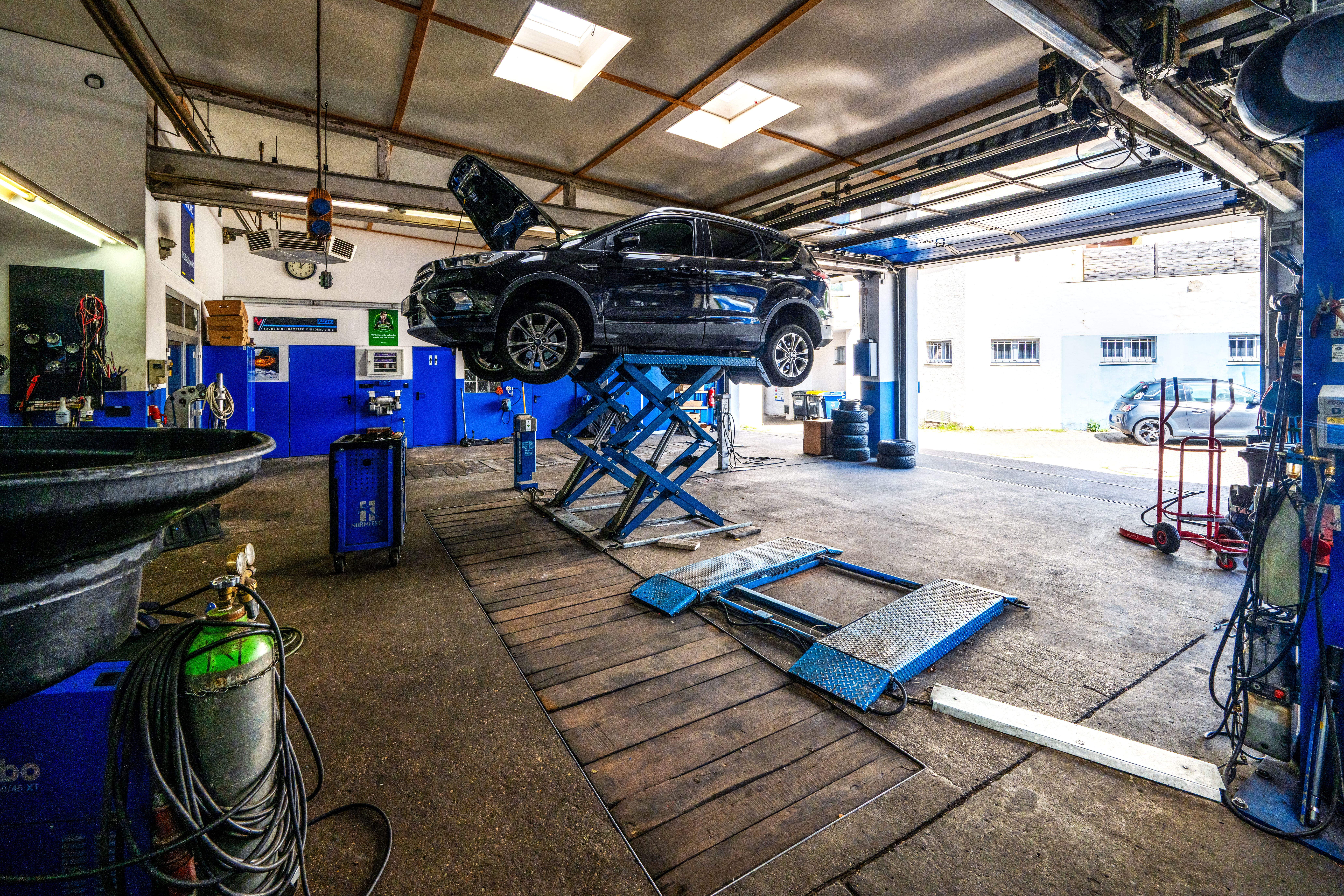Hebebühne und Fahrzeuge in der Werkstatt